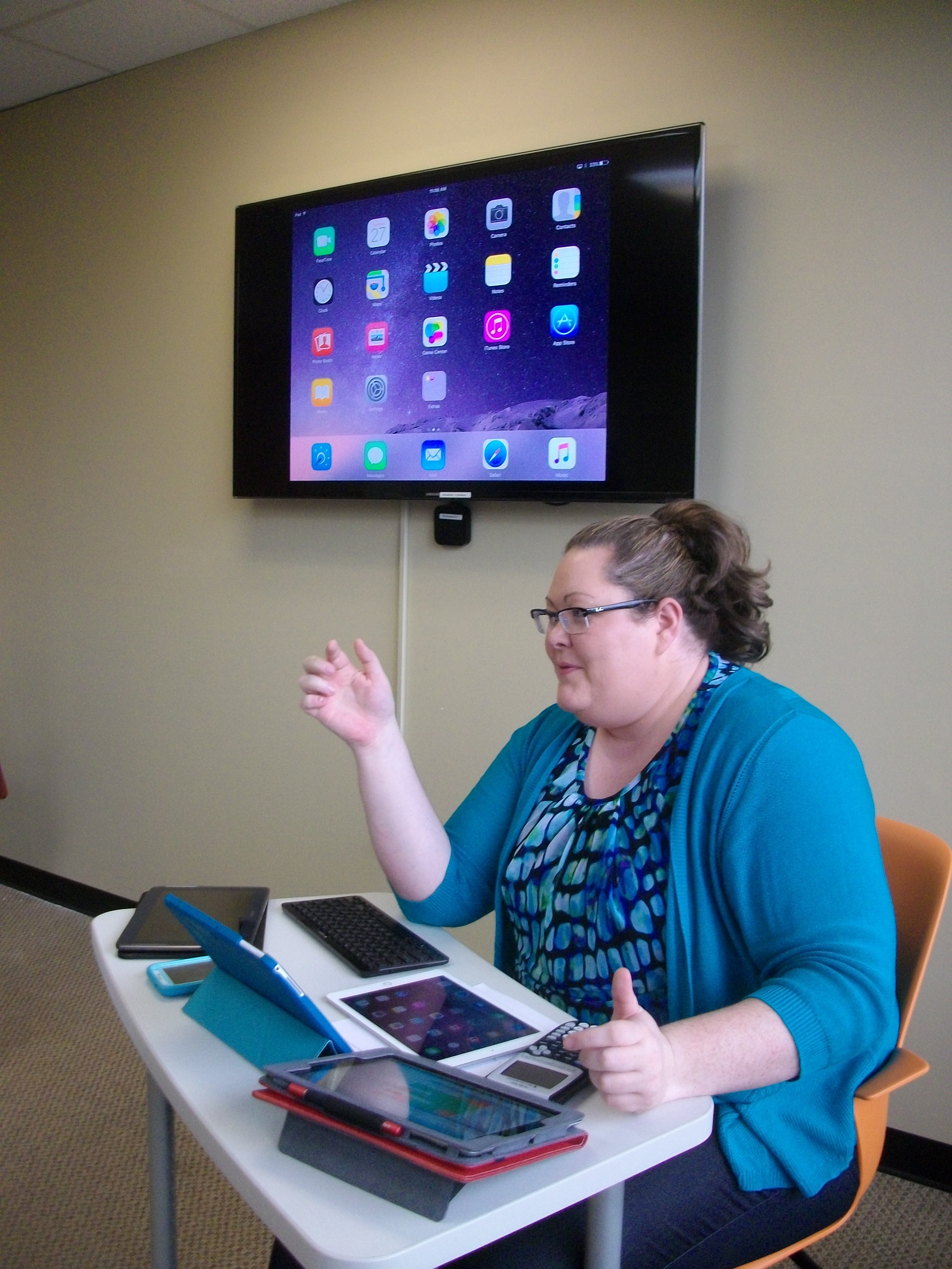 This is an image of Elizabeth Weaver teaching using a variety of mobile devices.